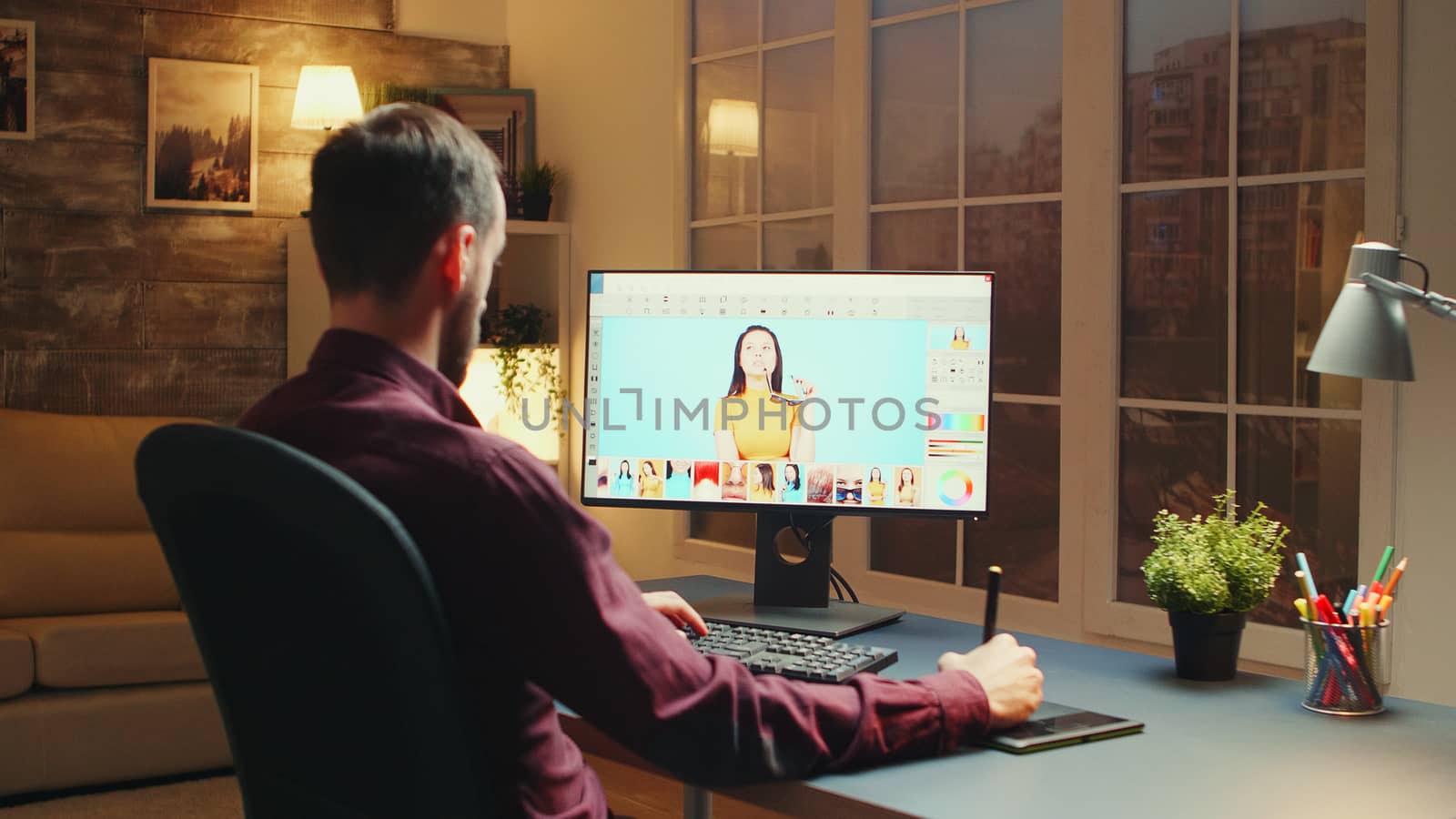 Professional photographer zooms in photo while retouching using graphic tablet.