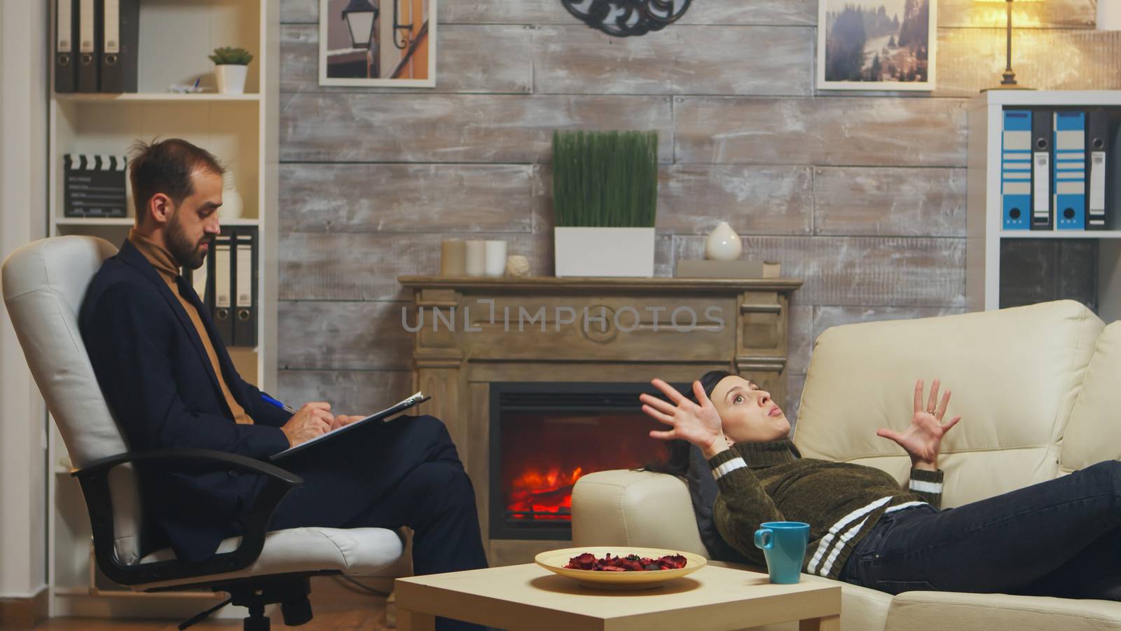 Young man laying on couch at couple therapy talking with psychologist.