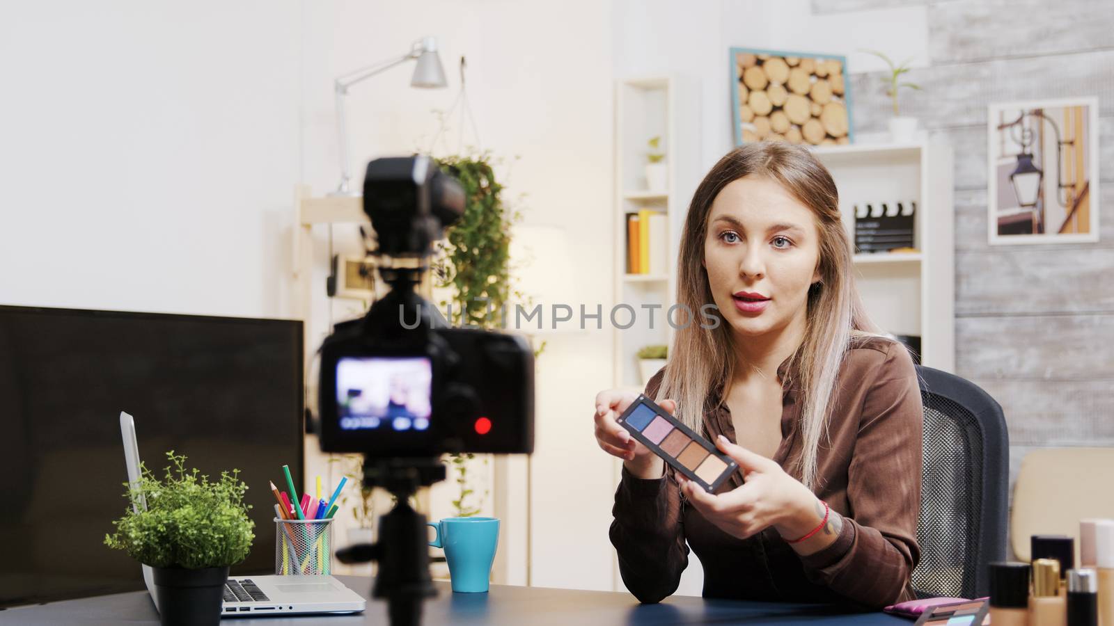 Influencer beauty vlogger recording tutorial for followers of how to use skin cosmetics.