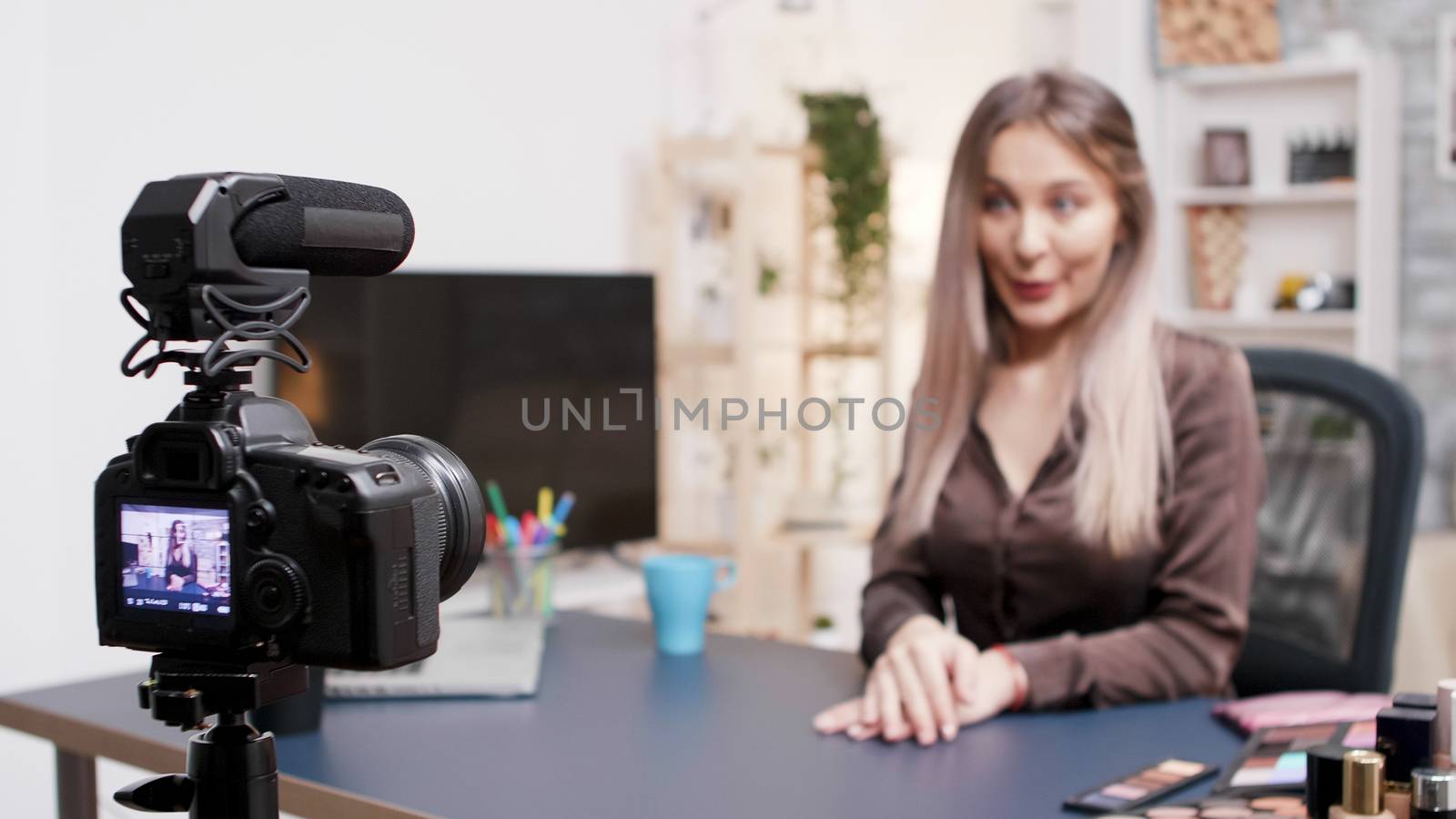 Beautiful beauty influencer recording a video about fashion makeup. Creative content creator.