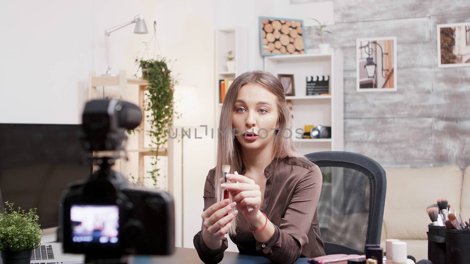 Famous beauty influencer showing how to use makeup brush. Social media star