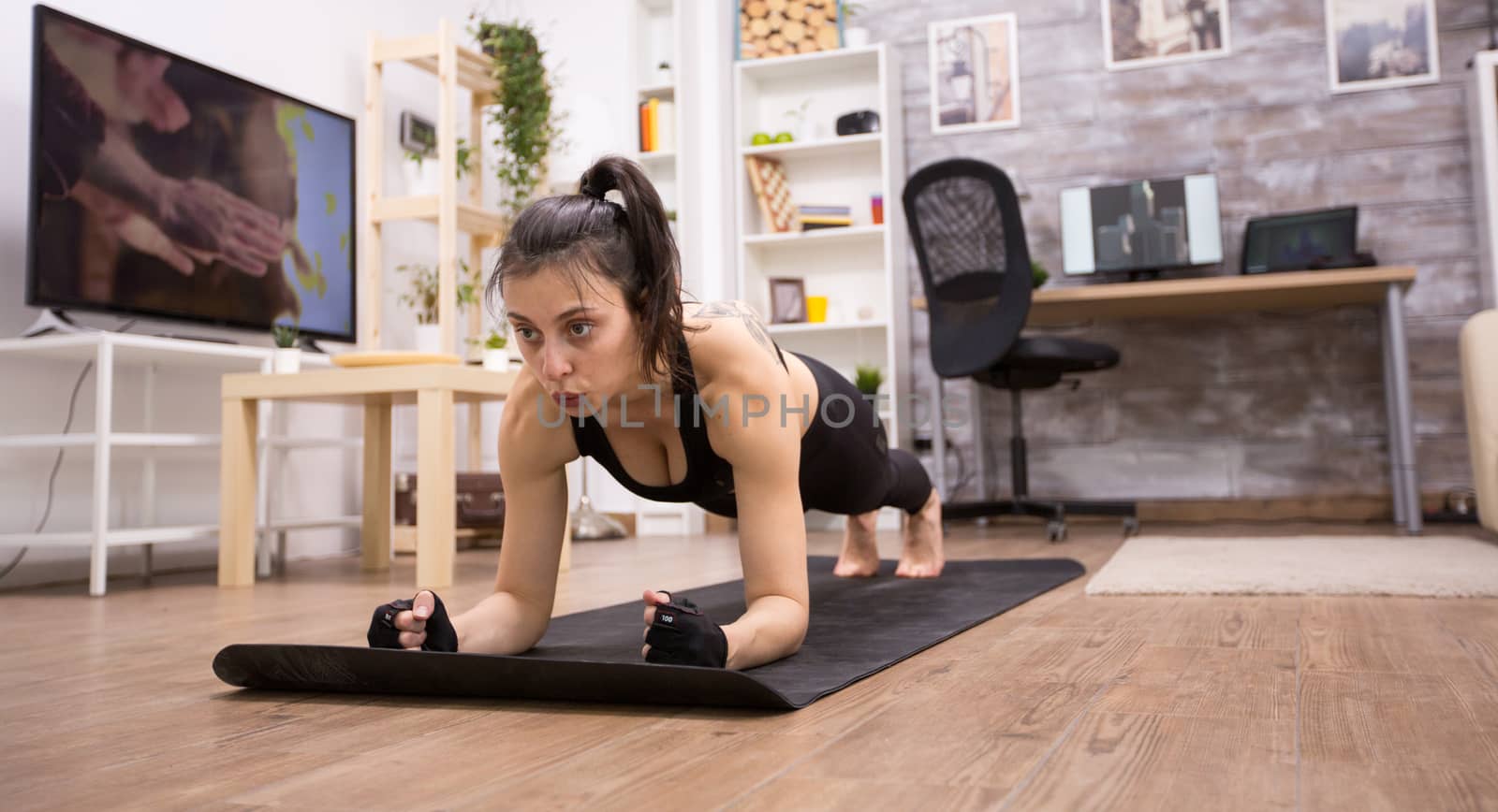 Adult woman doing plank exercise to improve her fitness. Fit female.