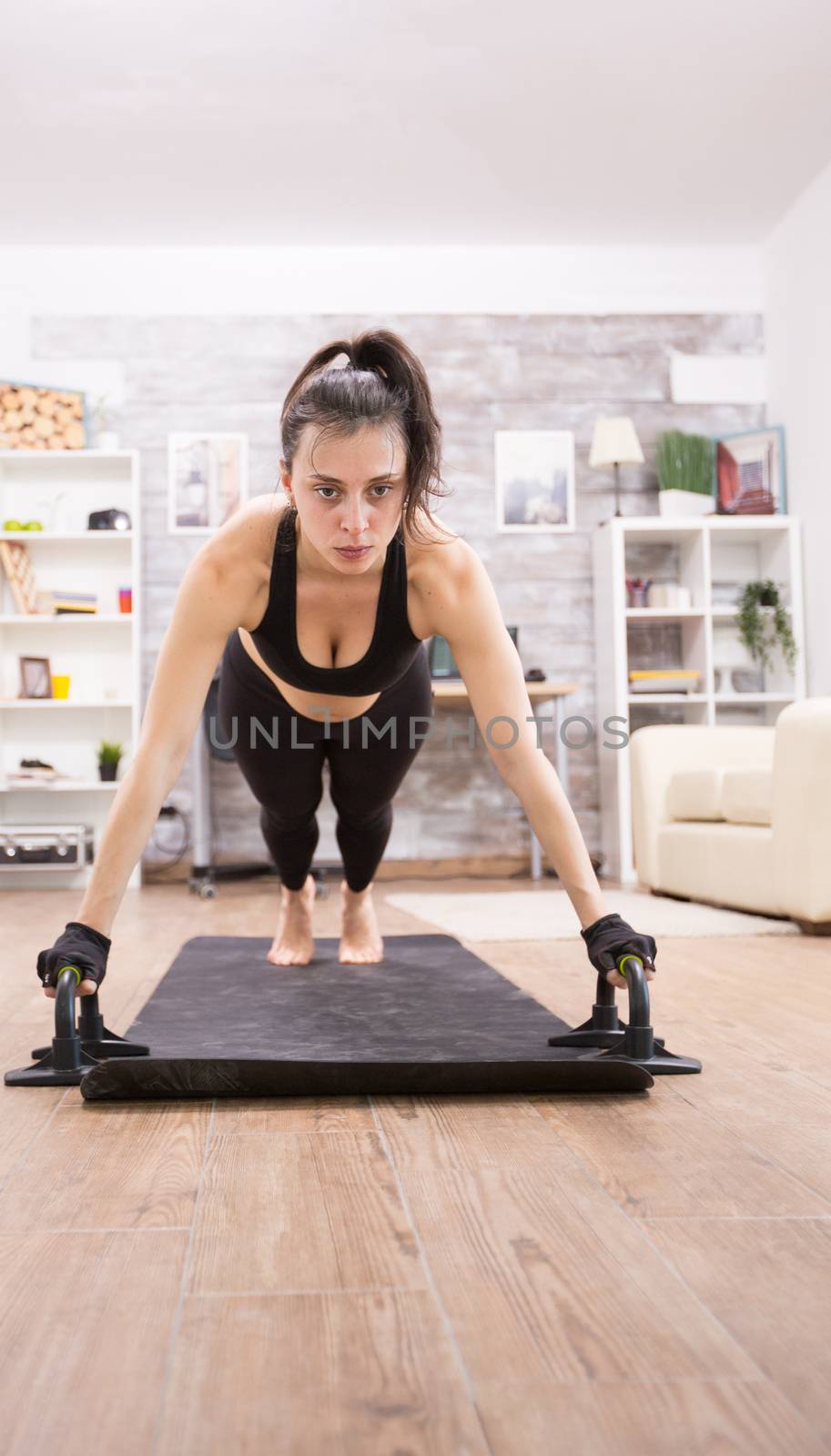 Attractive young woman doing push ups to have a fit body. Healthy lifestyle.