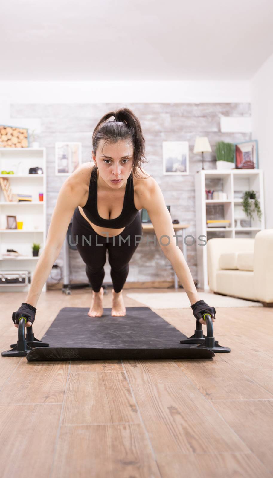 Attractive young woman doing push ups to have a fit body by DCStudio