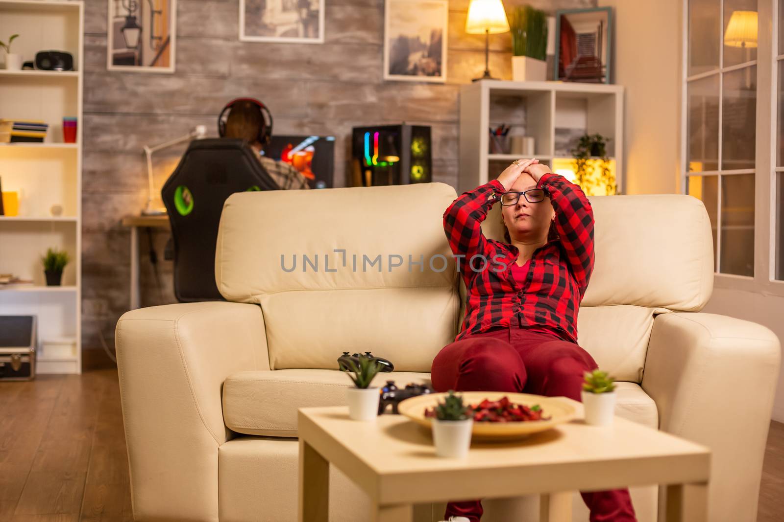Angry and frustrated woman gamer playing video games on the console late at night in the living room