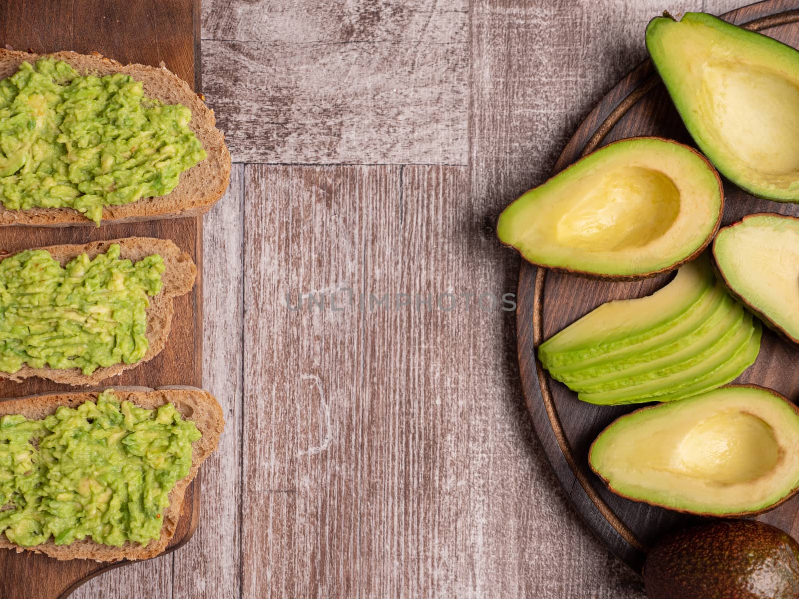 Top view of fresh sandwiches made with avocado on a wooden board