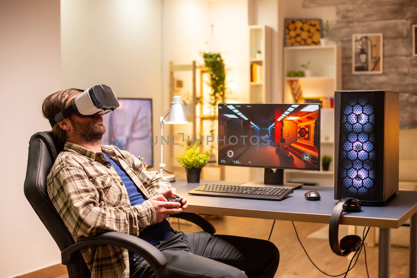 Professional gamer man using VR headset to play on powerful PC late at night in his living room