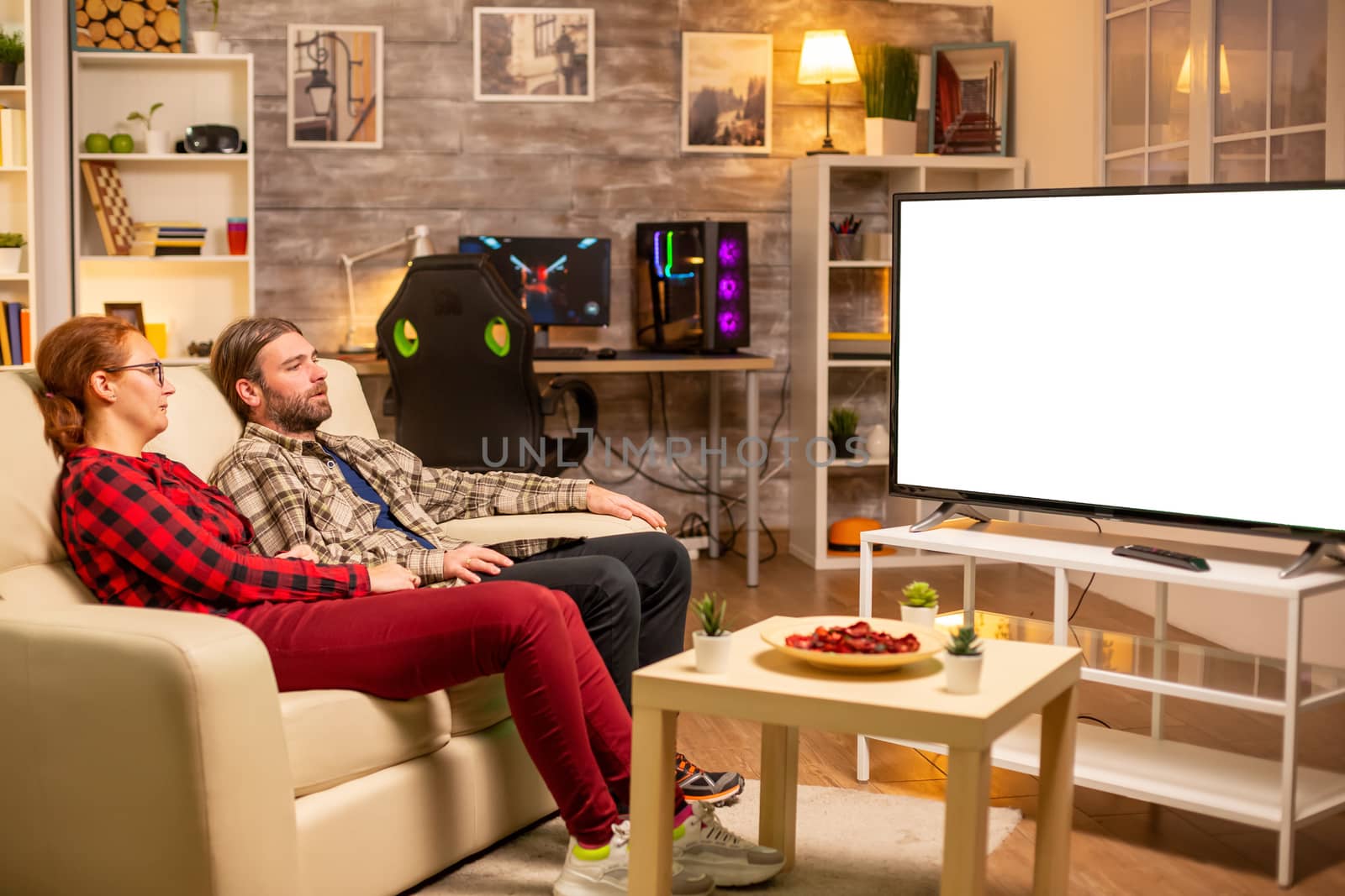 Couple looking at white isolated TV screen late at night in living room.