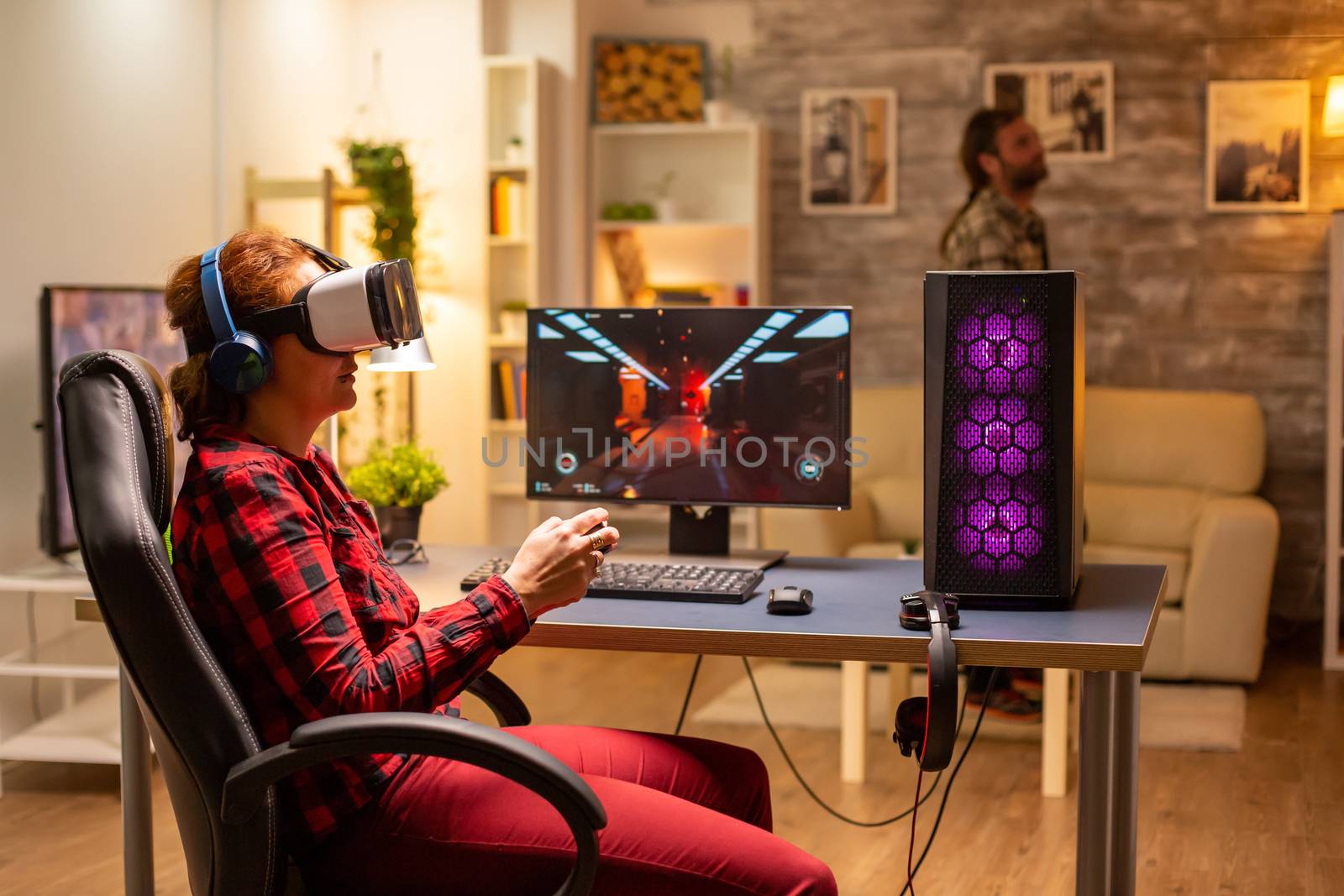 Femal gamer using a VR headset to play video games late at night in the living room.