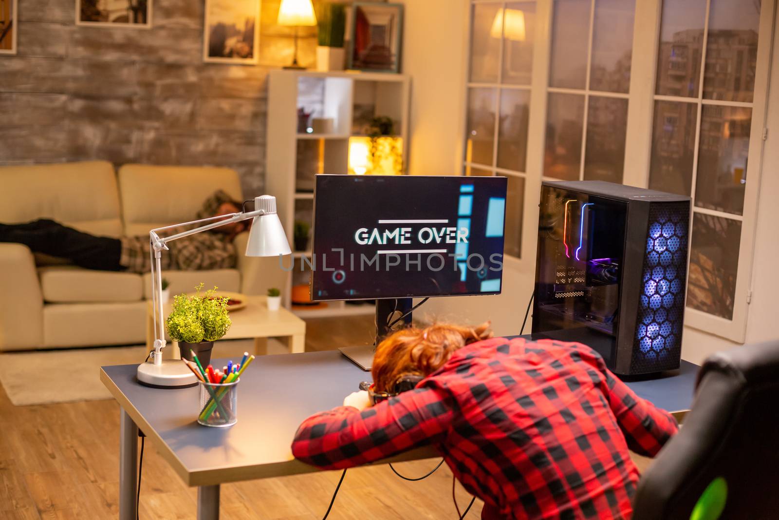 Gamer woman losing at a video game playing late at night in the living room.