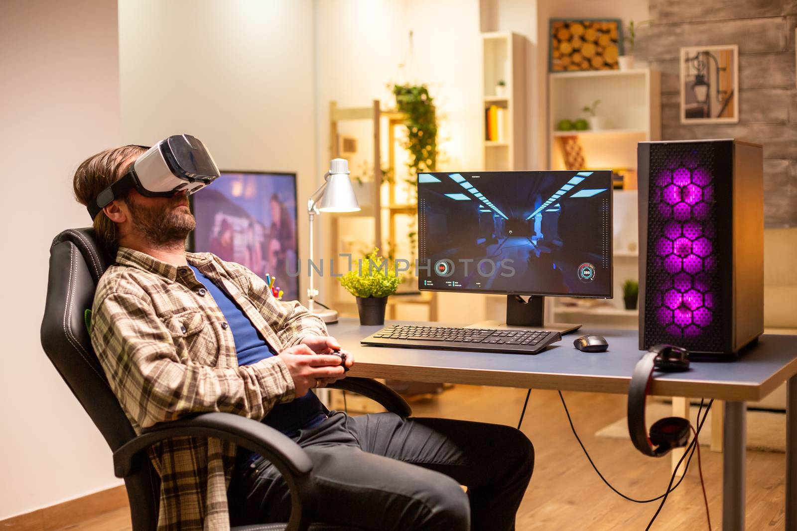 Professional gamer man using VR headset to play on powerful PC late at night in his living room