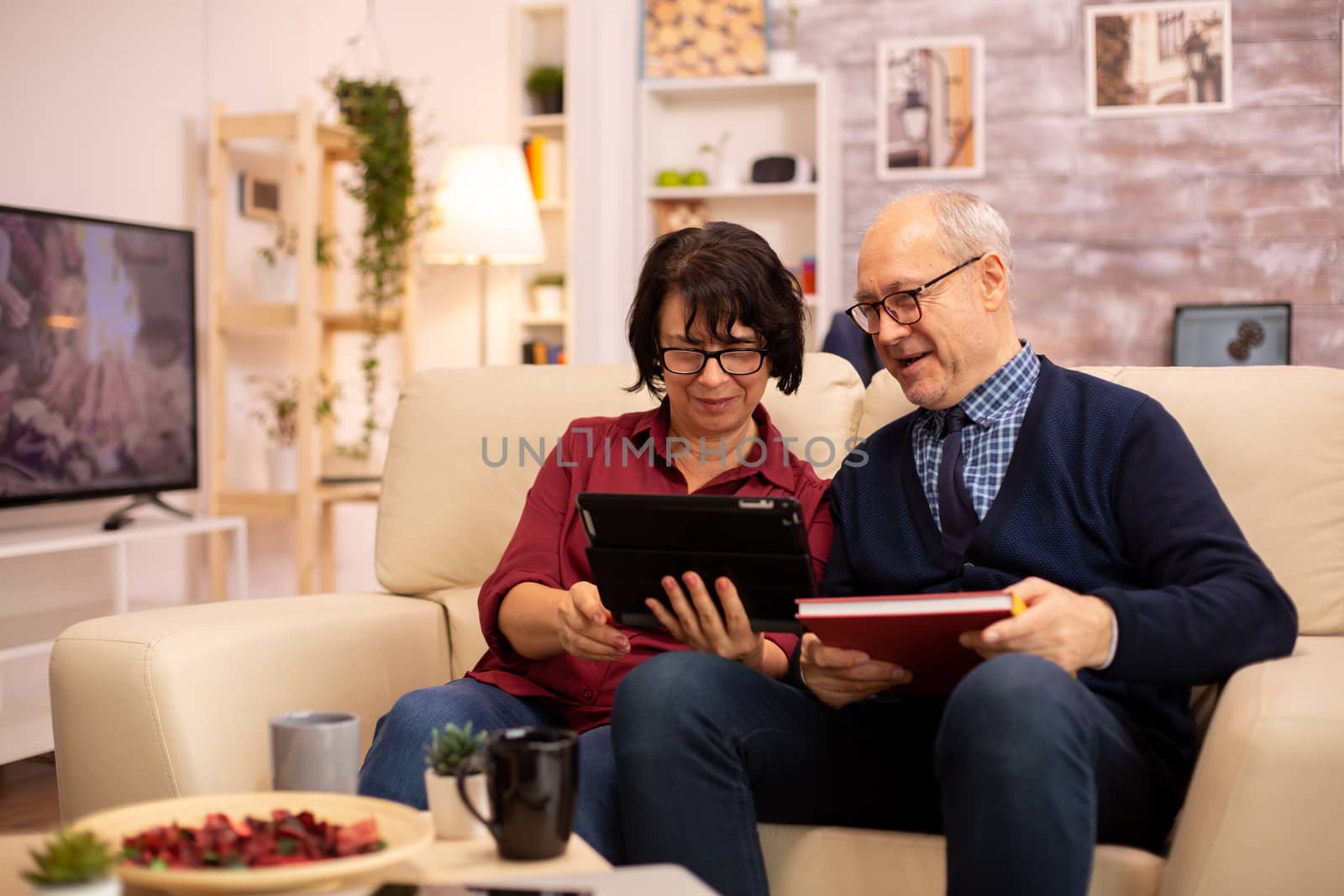 Beautiful old couple using a digital tablet to chat with their family. Elderly people using modern technology