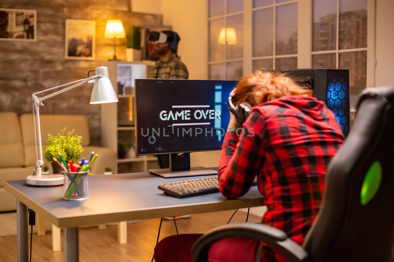 Gamer woman losing at a video game playing late at night in the living room.