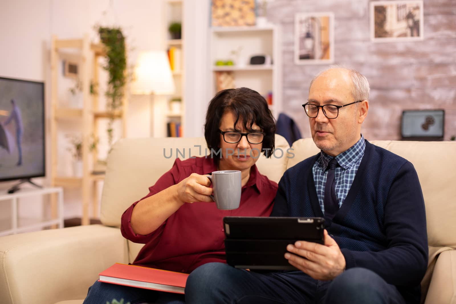 Beautiful old couple using a digital tablet to chat with their family. Elderly people using modern technology