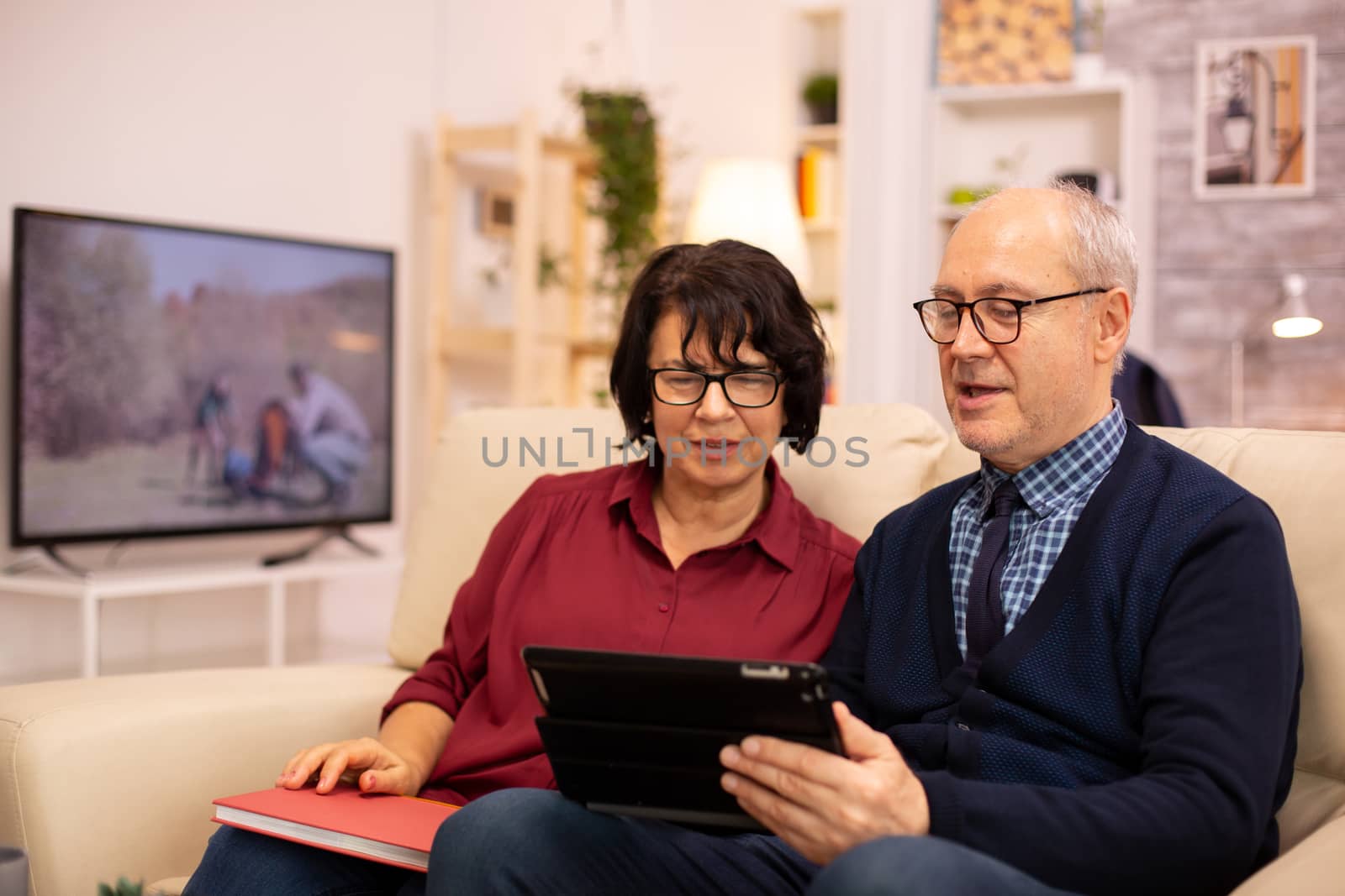 Beautiful old couple using a digital tablet to chat with their family. Elderly people using modern technology