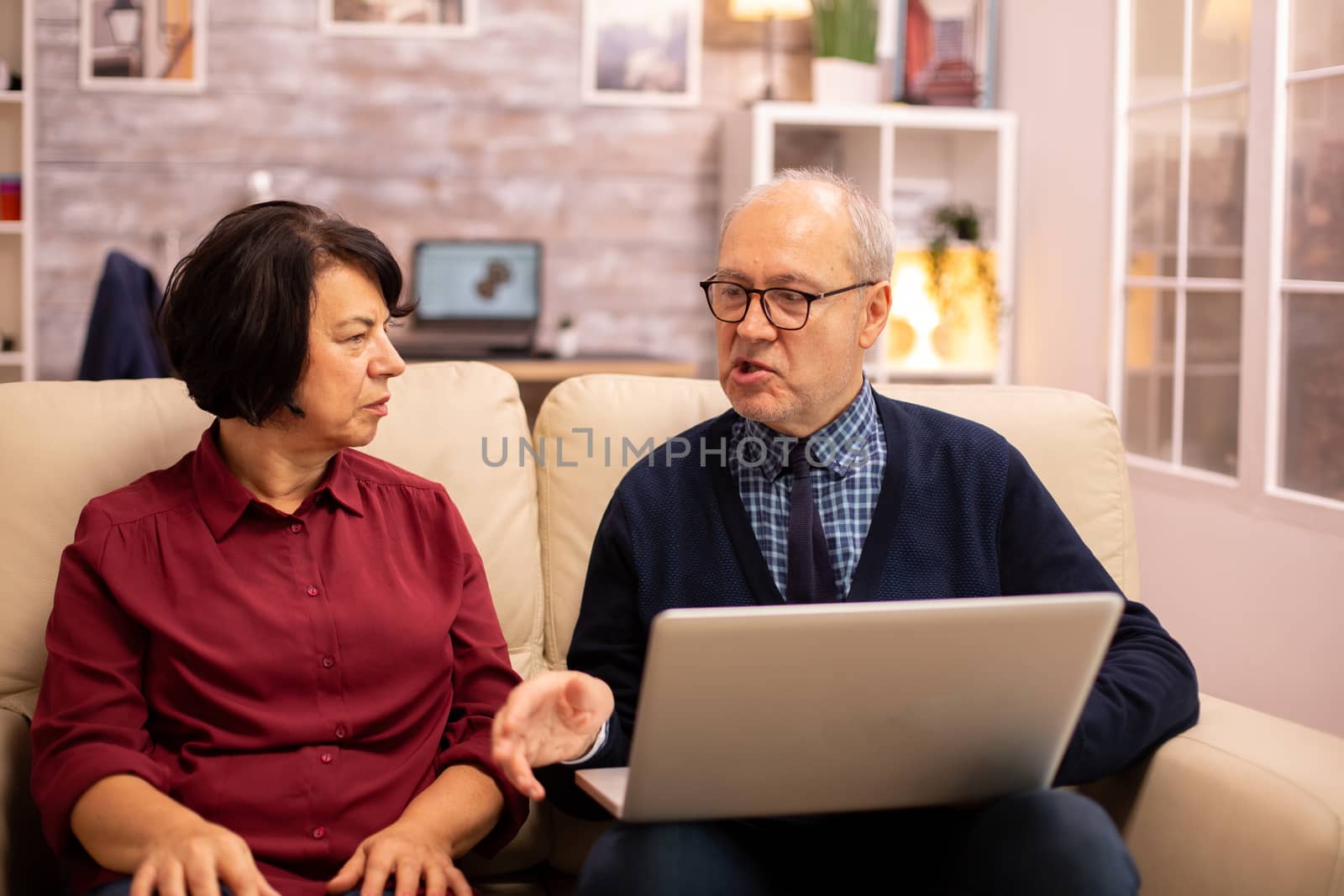 Elderly old couple using modern laptop to chat with their grandson. Grandmother and grandfather using modern technology