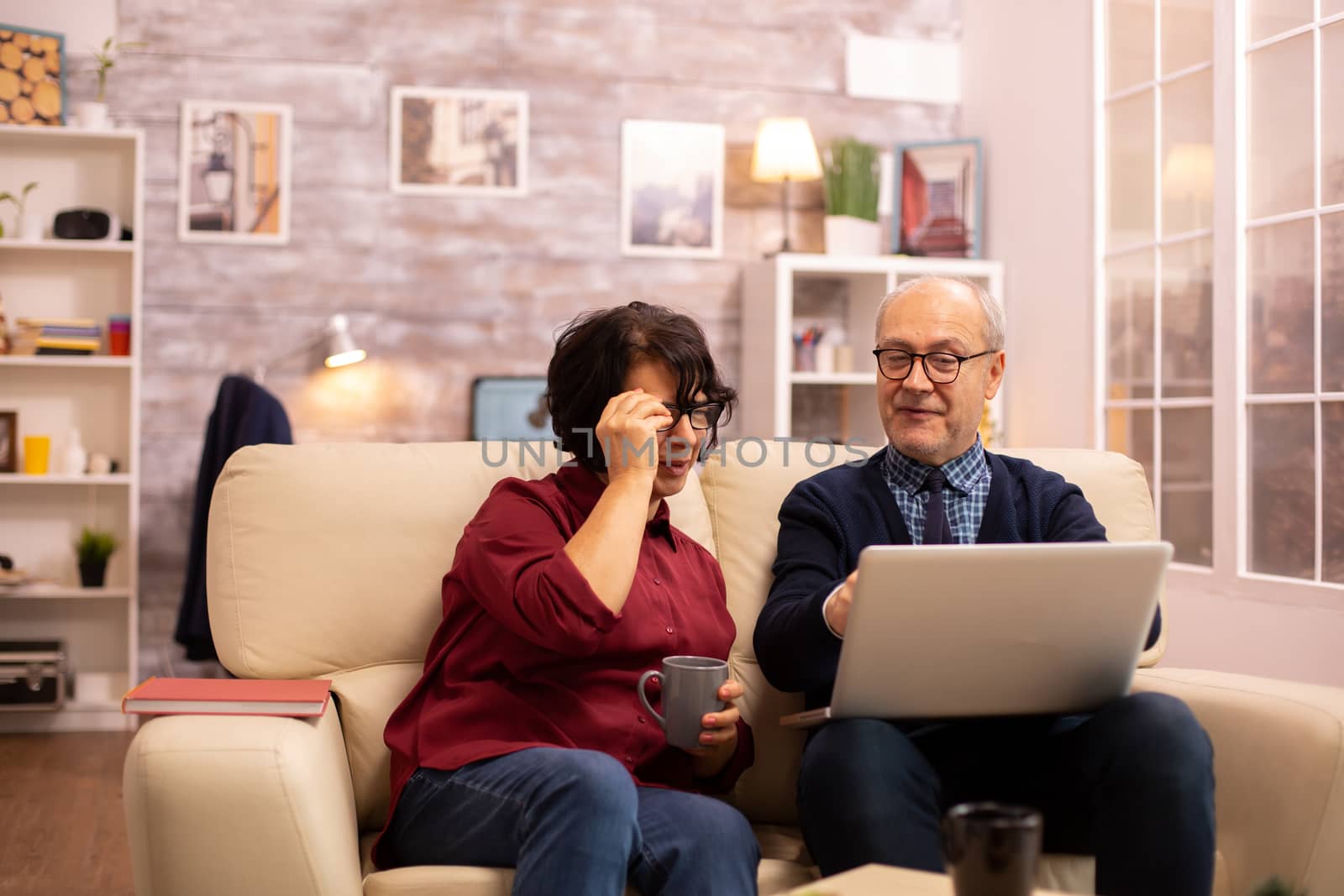 Elderly old couple using modern laptop to chat with their grandson. Grandmother and grandfather using modern technology