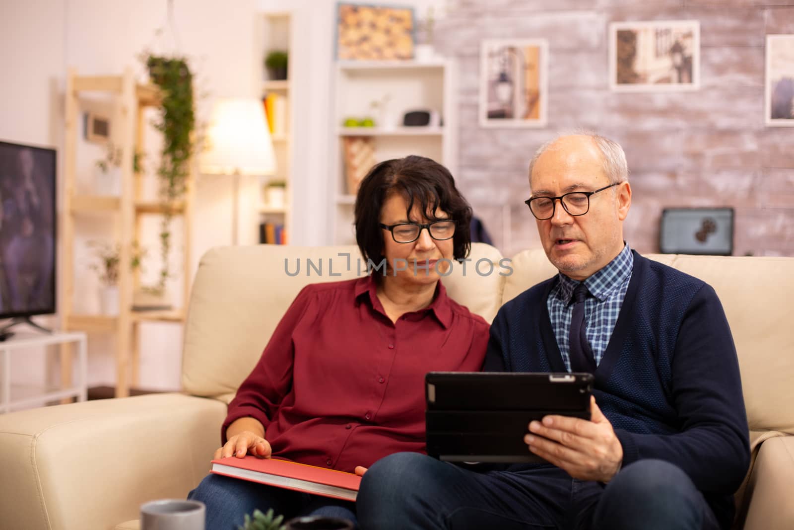 Beautiful old couple using a digital tablet to chat with their family. Elderly people using modern technology