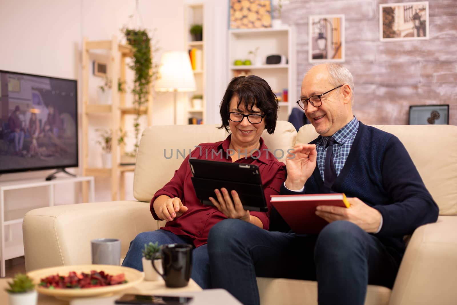 Beautiful old couple using a digital tablet to chat with their family. Elderly people using modern technology