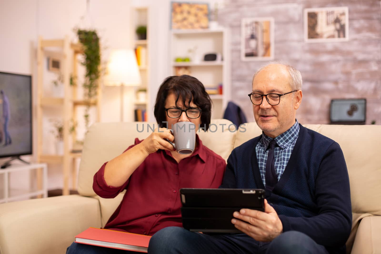 Beautiful old couple using a digital tablet to chat with their family by DCStudio