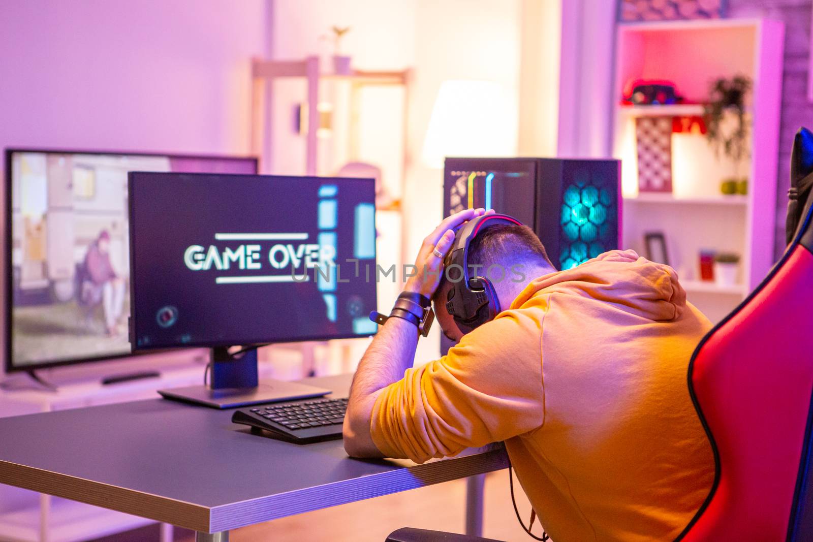 Upset professional gamer because he lost an important game. Room full of neon lights.