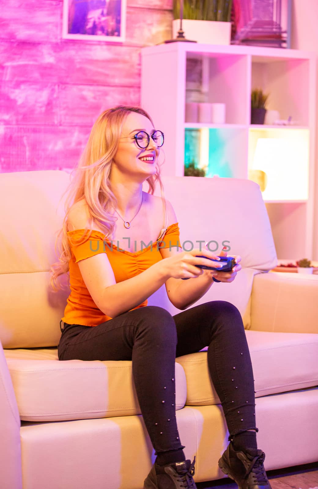 Beautiful blonde girl excited while playing video games by DCStudio