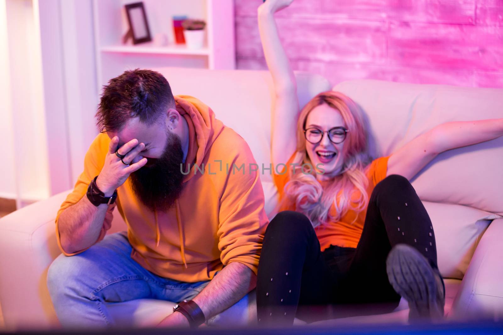 Blond girlfriend happy to win against her boyfriend on video games by DCStudio