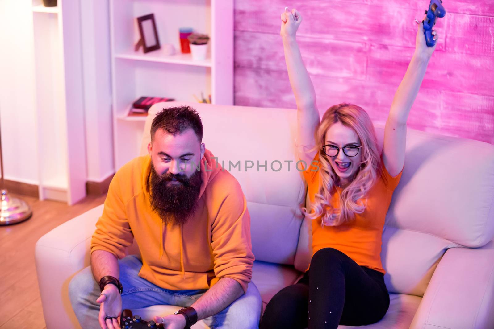Cheerful girlfriend after beating his boyfriend at online video games by DCStudio
