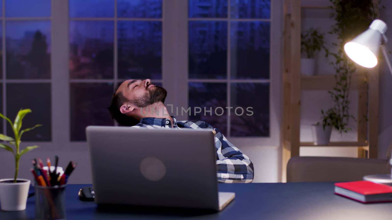 Tired businessman sleeping on chair in his home office. Overworked entrepreneur.