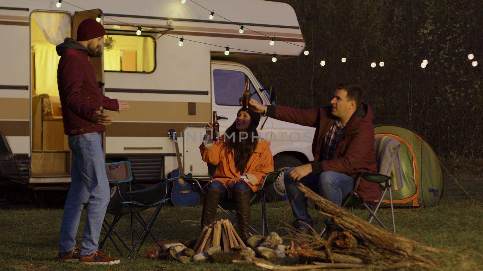 Man making his friend happy turning on the light bulbs. Retro camper van.