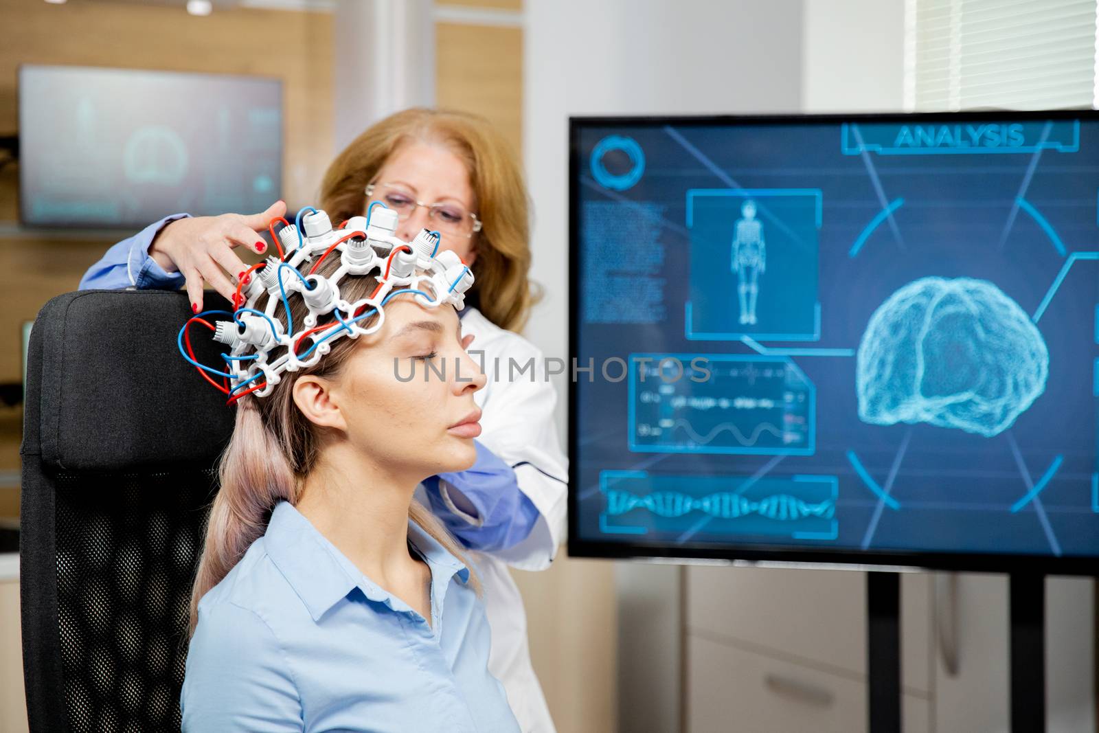 Doctor arranging scanning device on head of a female patient.