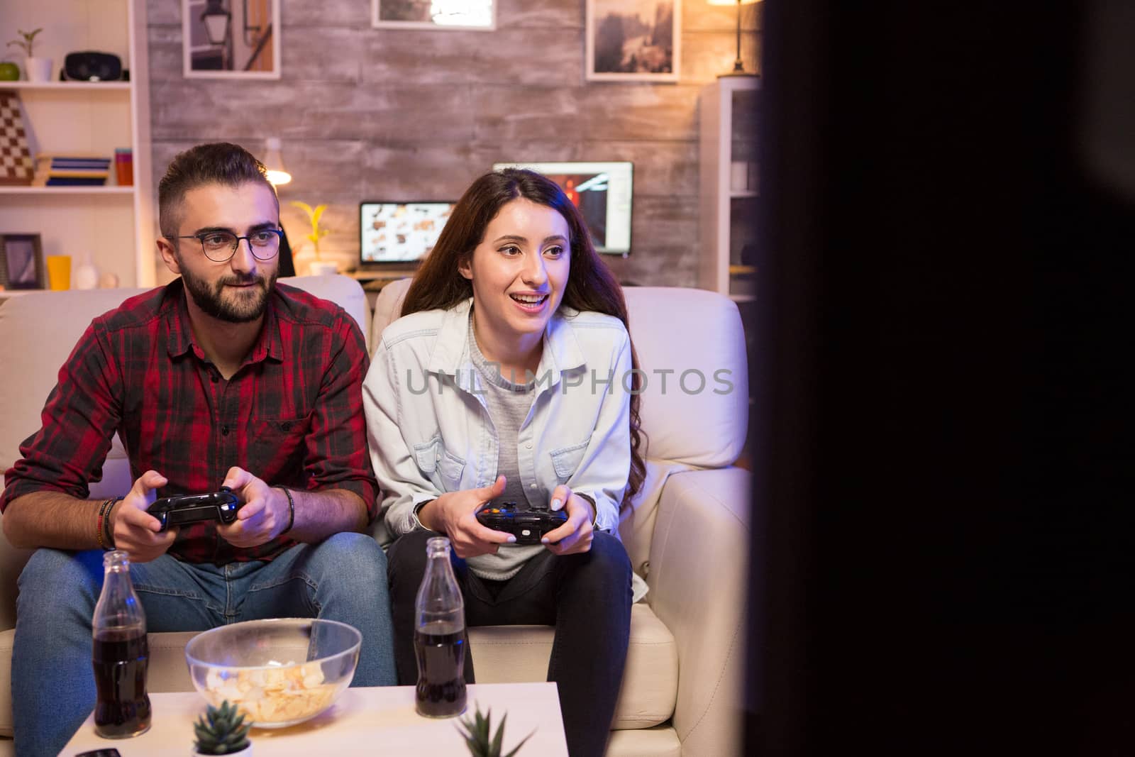 Concentrated young couple while playing video games by DCStudio