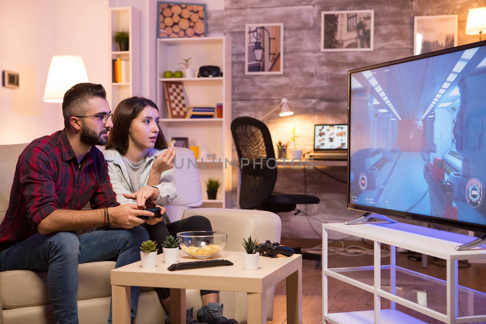 Boyfriend playing video games on television using controller by DCStudio