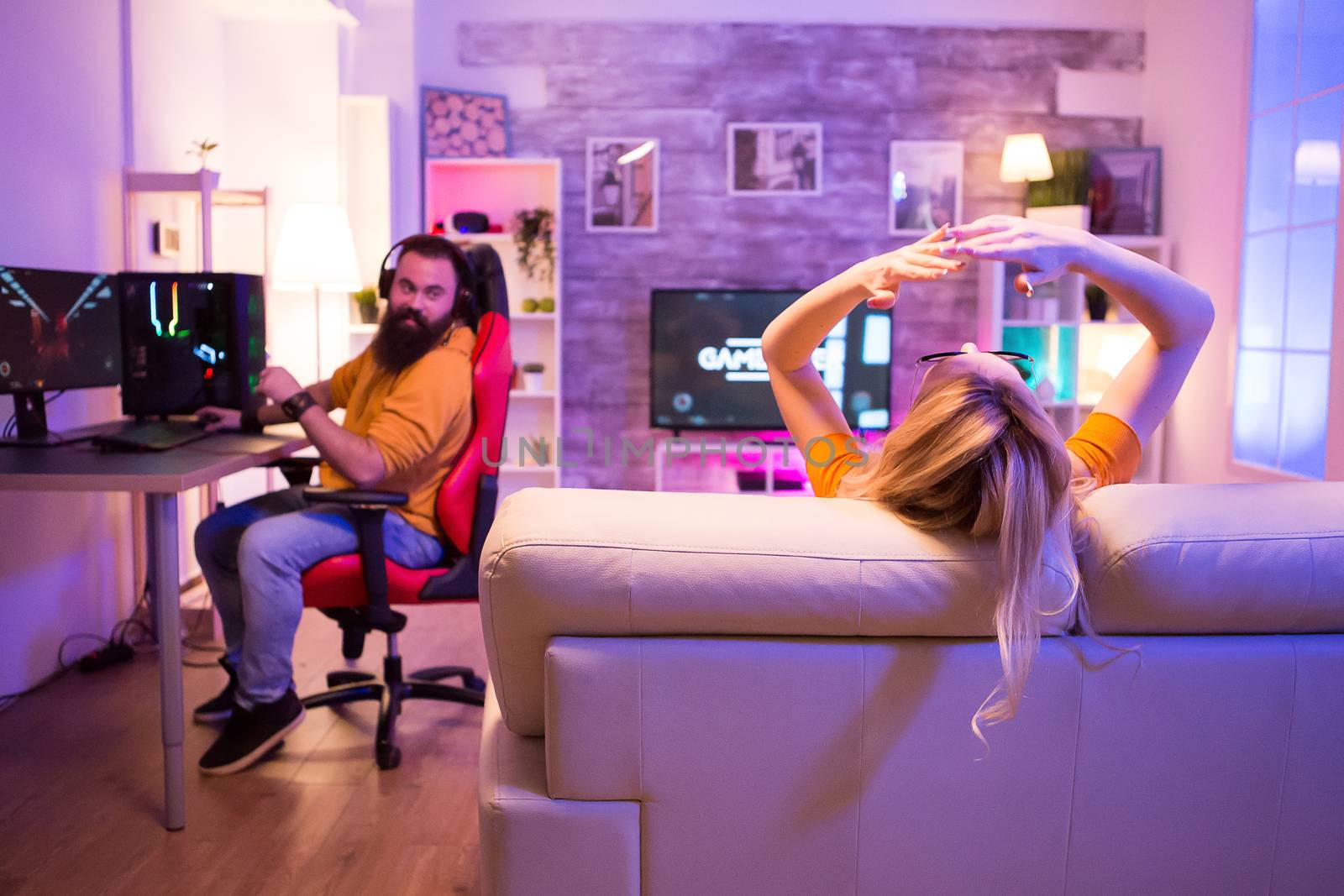 Back view of game over for a girl while playing video games on television. Male on gaming chair.