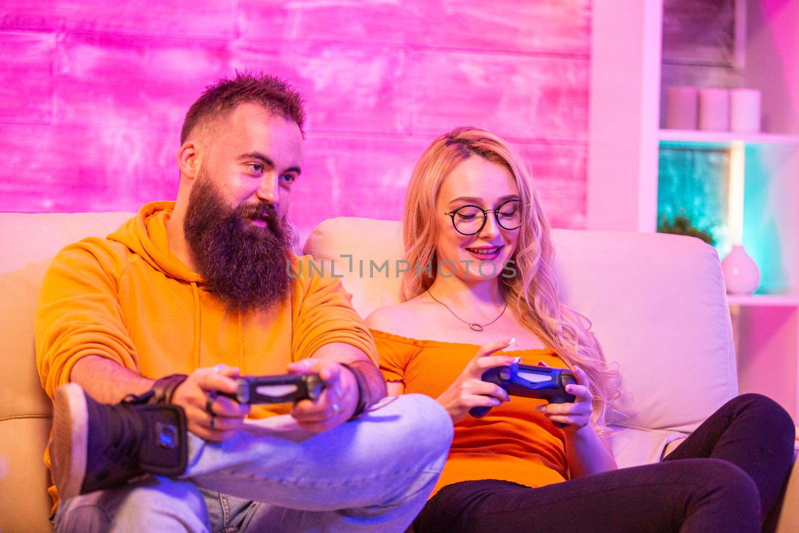 Beautiful blonde girl smiling while playing video games by DCStudio