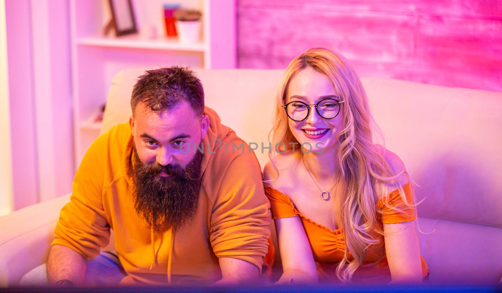 Beautiful blonde girl smiling while playing video games by DCStudio