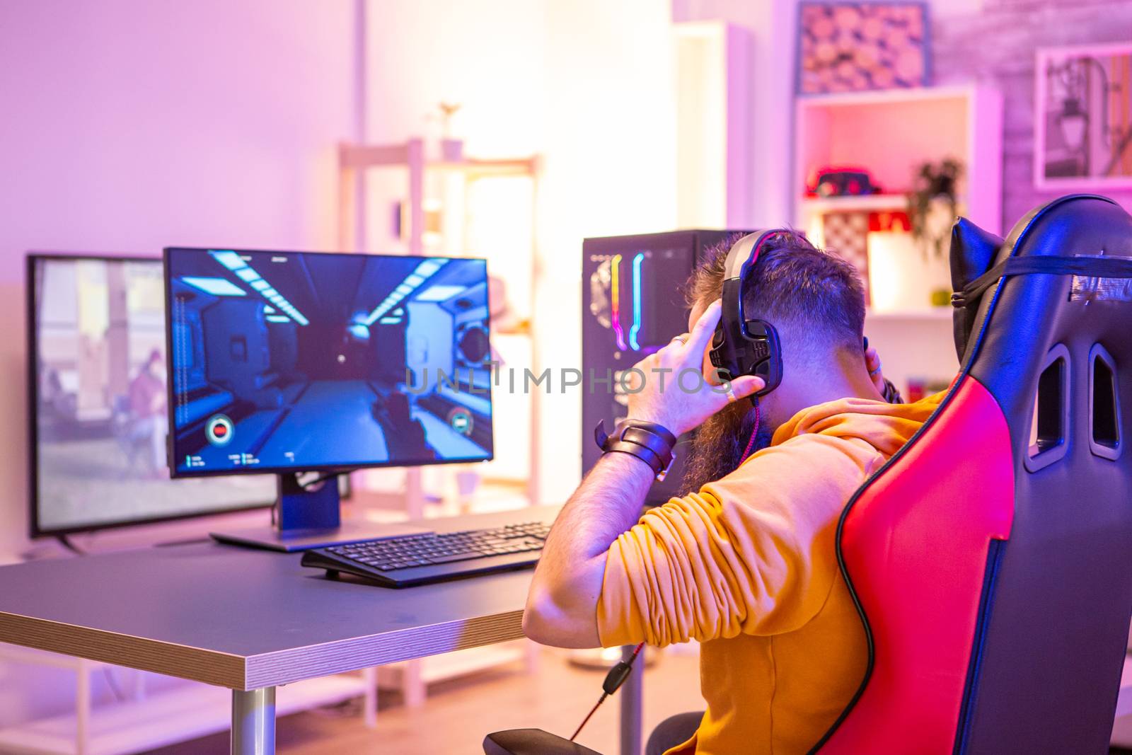 Bearded man playing online video games on his pc by DCStudio