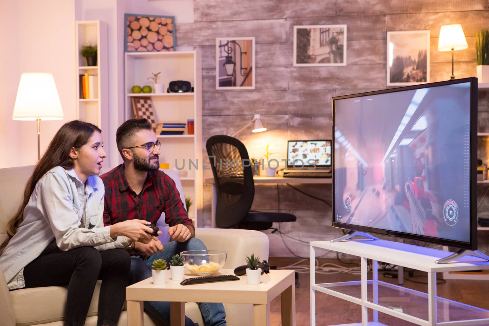 Relaxed girlfriend playing video games on television. Couple playing games.