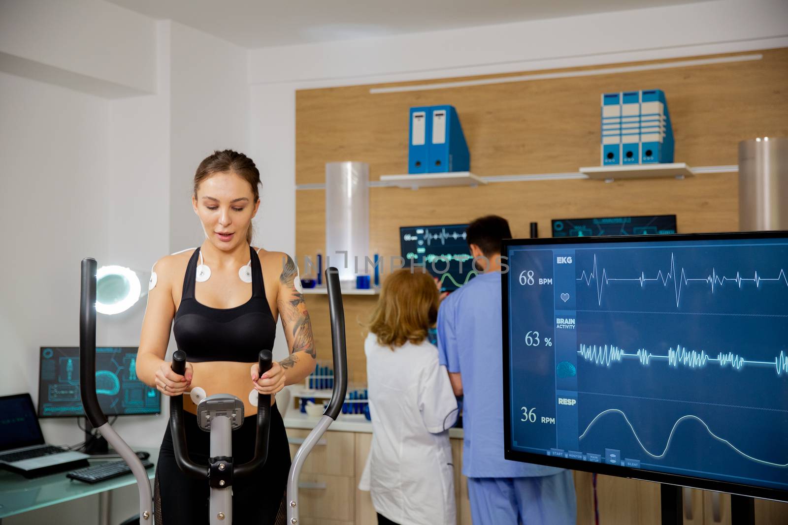 Female athlete who makes a physical effort on the stepper and has electrodes and heartbeats attached to it. Tests to run