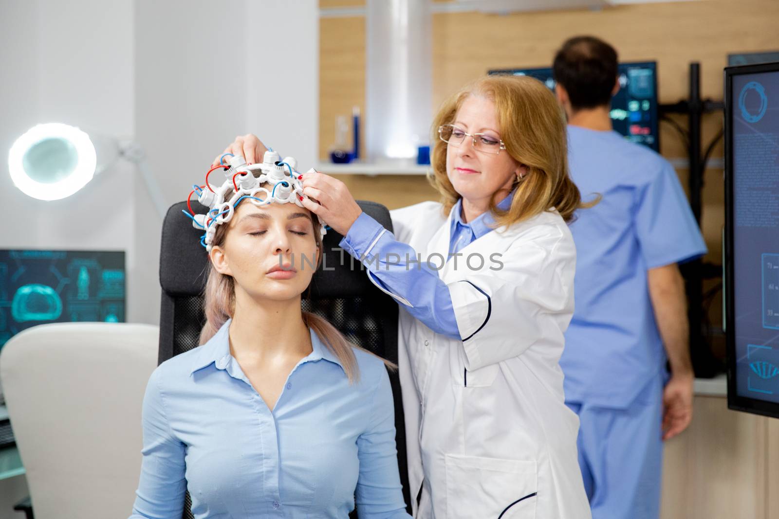 Doctor installing scanning device on the head of a female patient. Brain activity