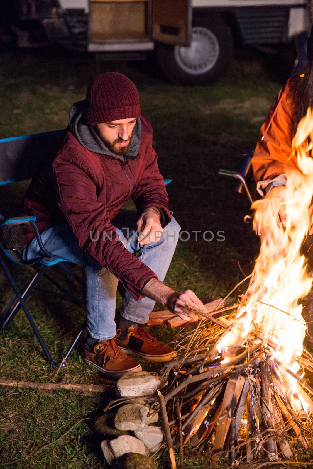 Bearded tourist in the mountains making camp fire by DCStudio