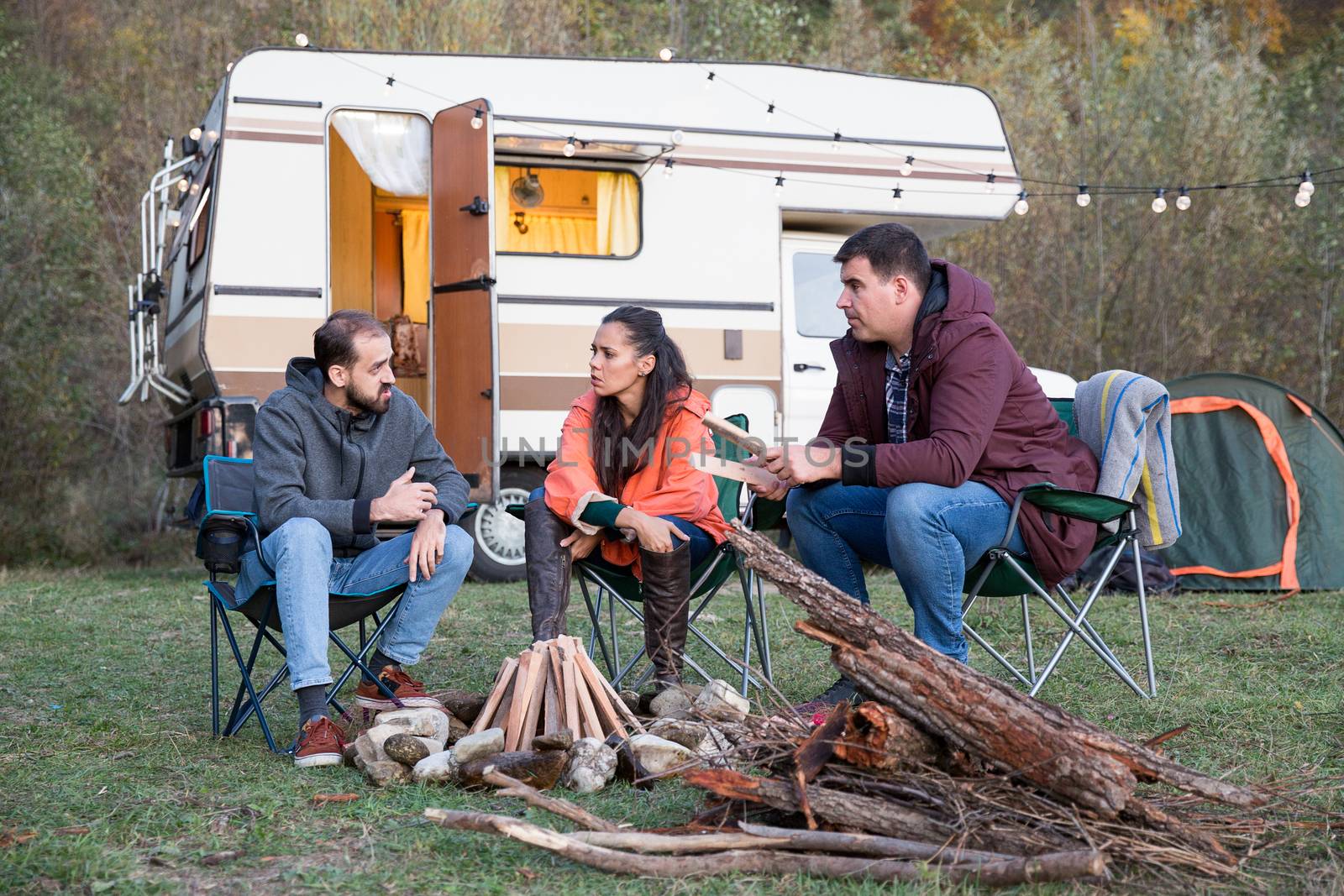 Group of friends escaping from city agitation and camping in the mountains with their retro camper van.