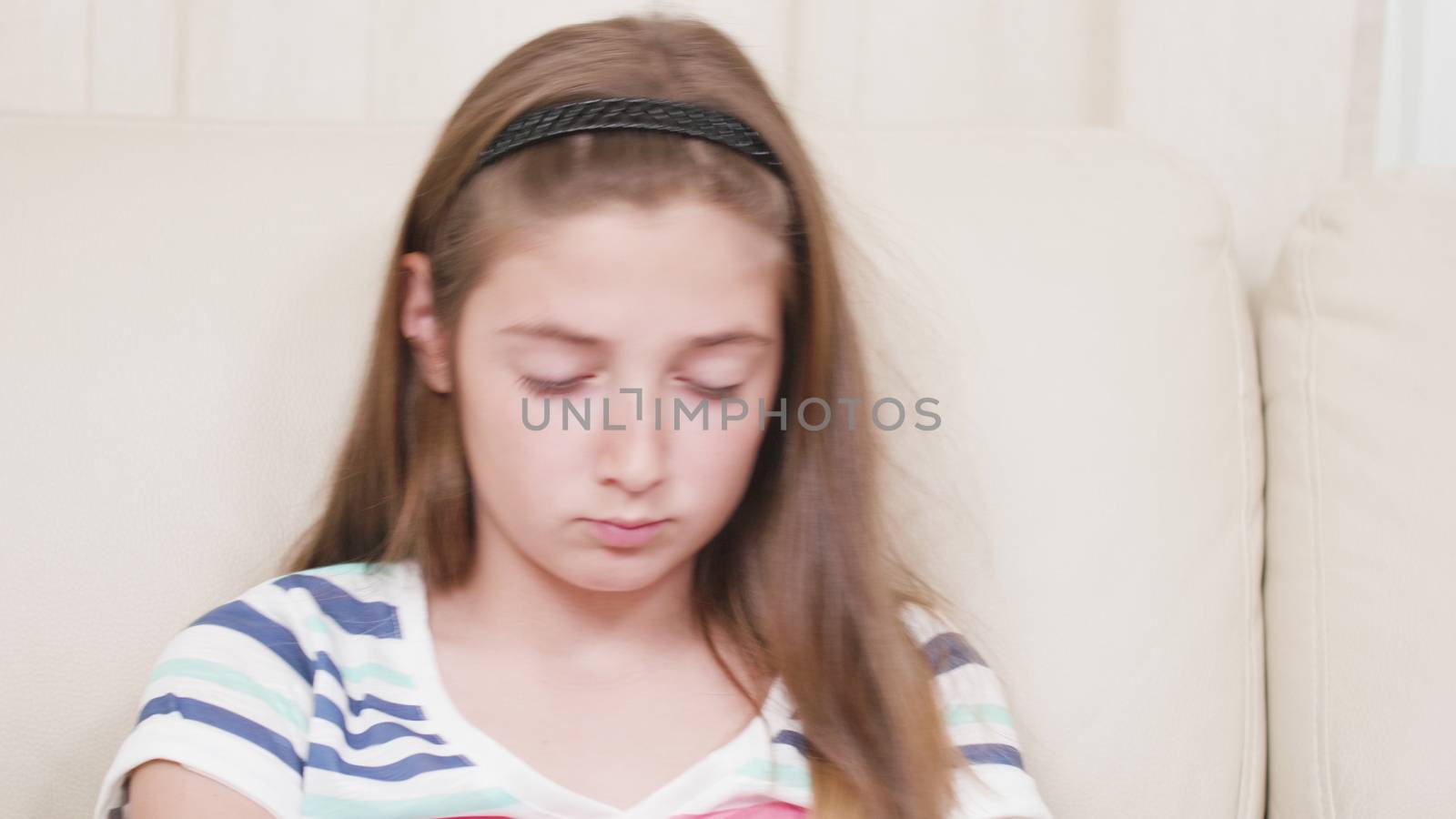 Close up portrait of a young girl gaming on a smartphone. Playing a game in the living room.