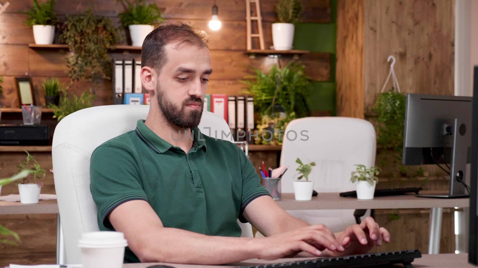 Office worker in casual clothes works on the computer. Zoom in slow motion shot