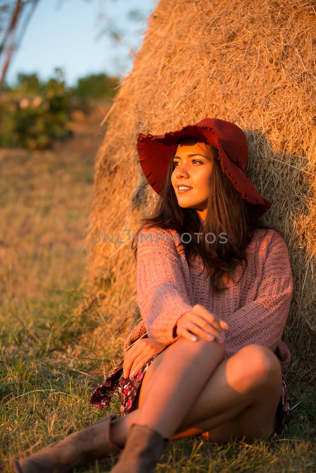 Portrait of young brunette woman in vineyard with stylish hat.