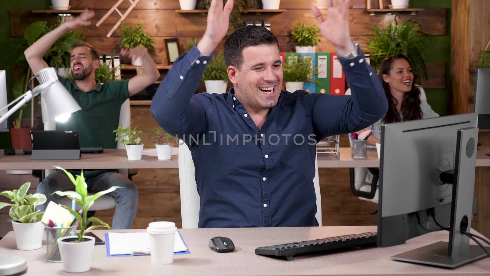 Happy office workers are celebrating a big sale in a cozy office. Start-up company. Slow motion footage