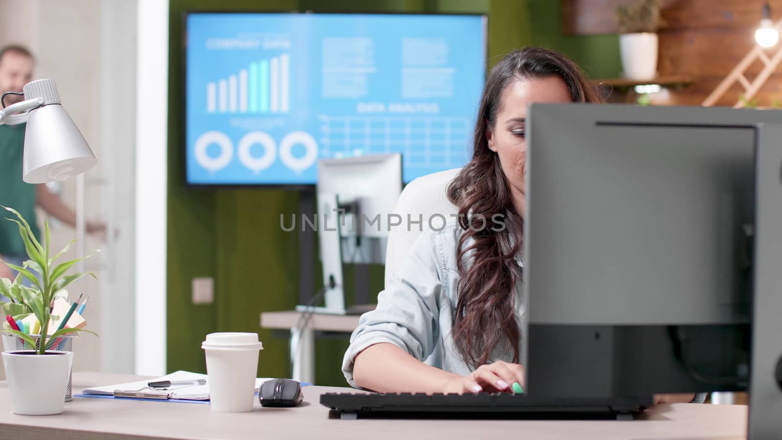 Revealing shot of woman working in cozy office. Start-up company work environment