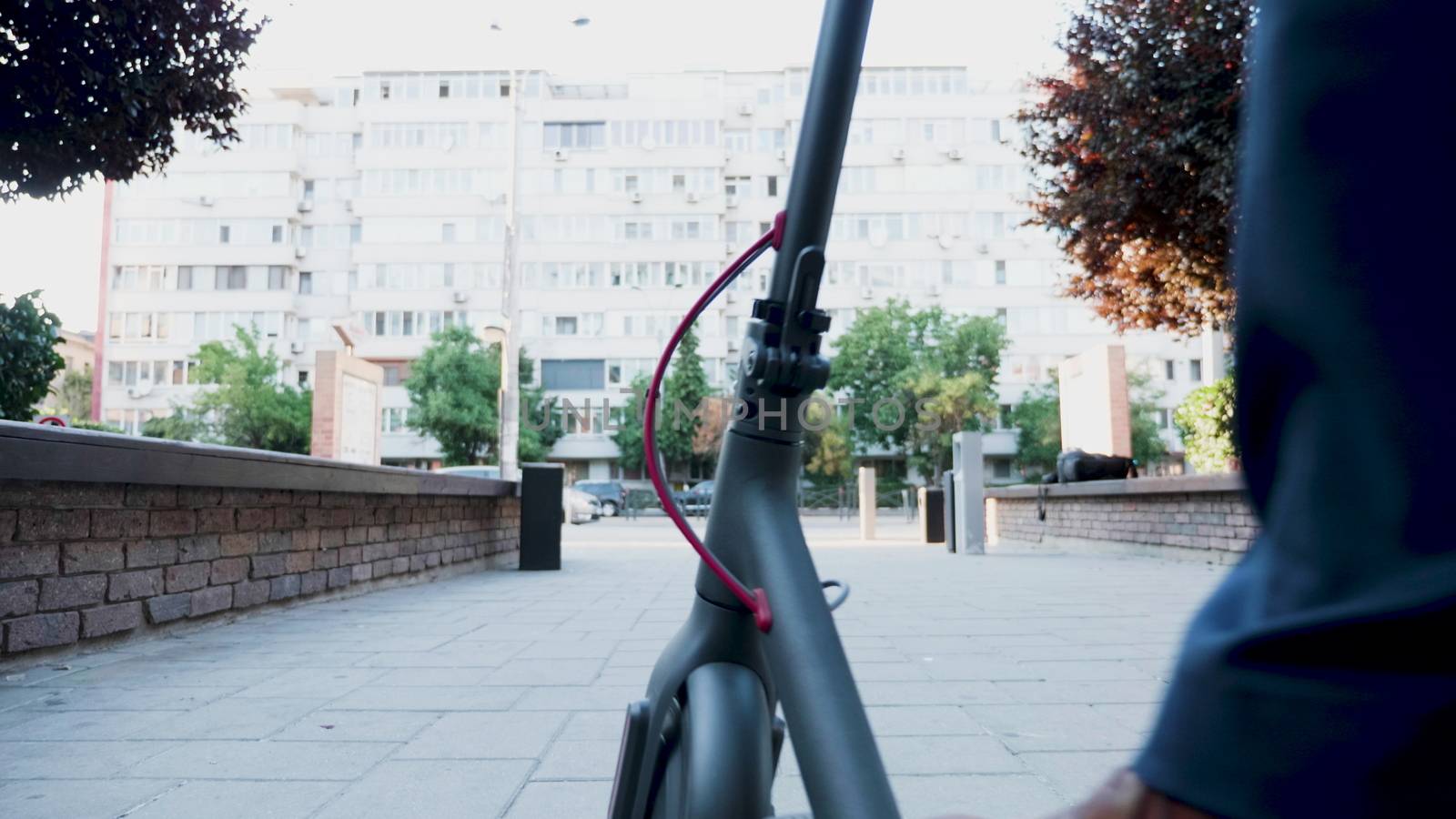 Man in formal suit riding an electric scooter in the city. Environmentally friendly businessman