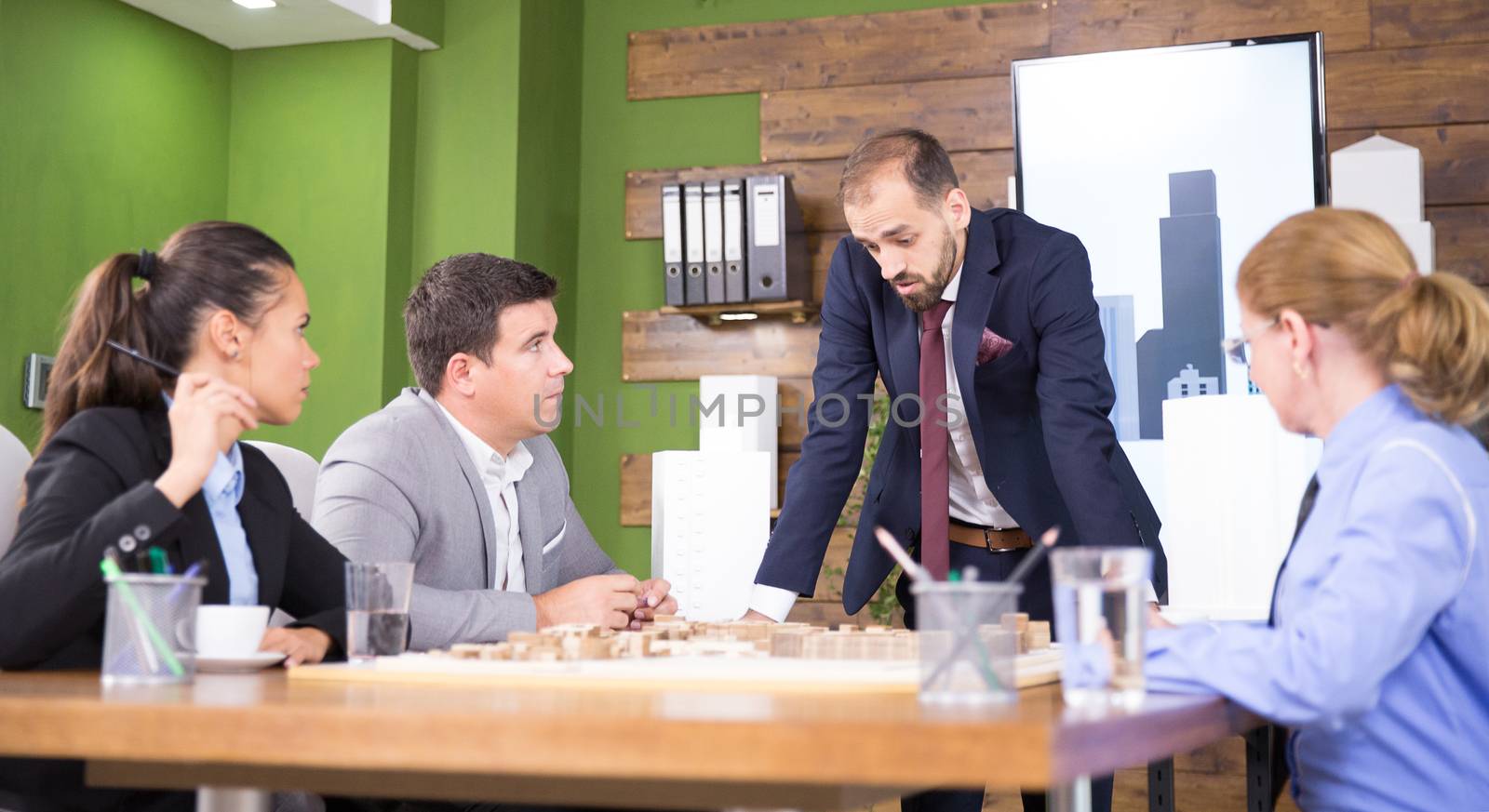 Successful real estate developers in a conference room with mini town on desk.