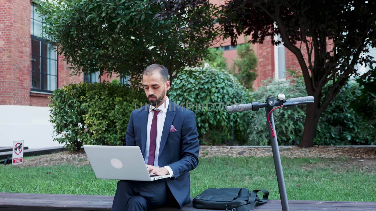 Businessman working on the laptop outdoor, slow motion zoom in footage. Business on the go